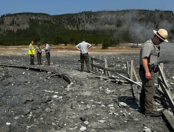 Park staff assess the damage to Biscuit Basin boardwalks after hydrothermal explosion